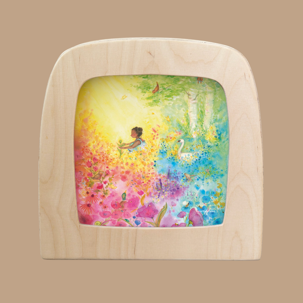The "Silhouette Only - Into Bloom Silhouette for Toverlux Lamp" features a whimsical scene of a young girl among vibrant flowers with a swan, crafted by Anne Illustraties to create a dreamy, magical atmosphere when displayed in your lamp.