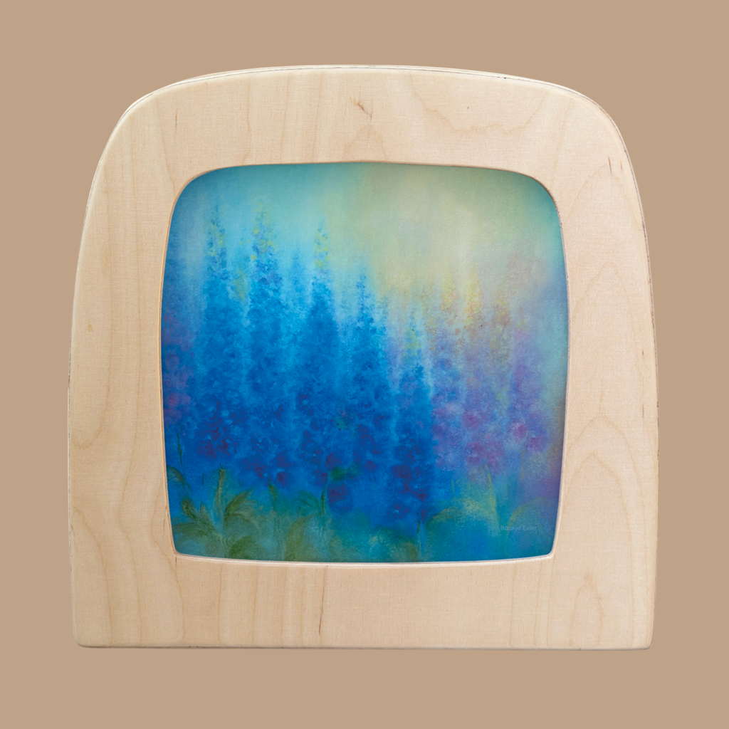 A wooden frame features the "Silhouette Only - Delphinium Silhouette for Toverlux Lamp": tall blue and purple flower silhouettes with green leaves against a misty, light blue and green backdrop.