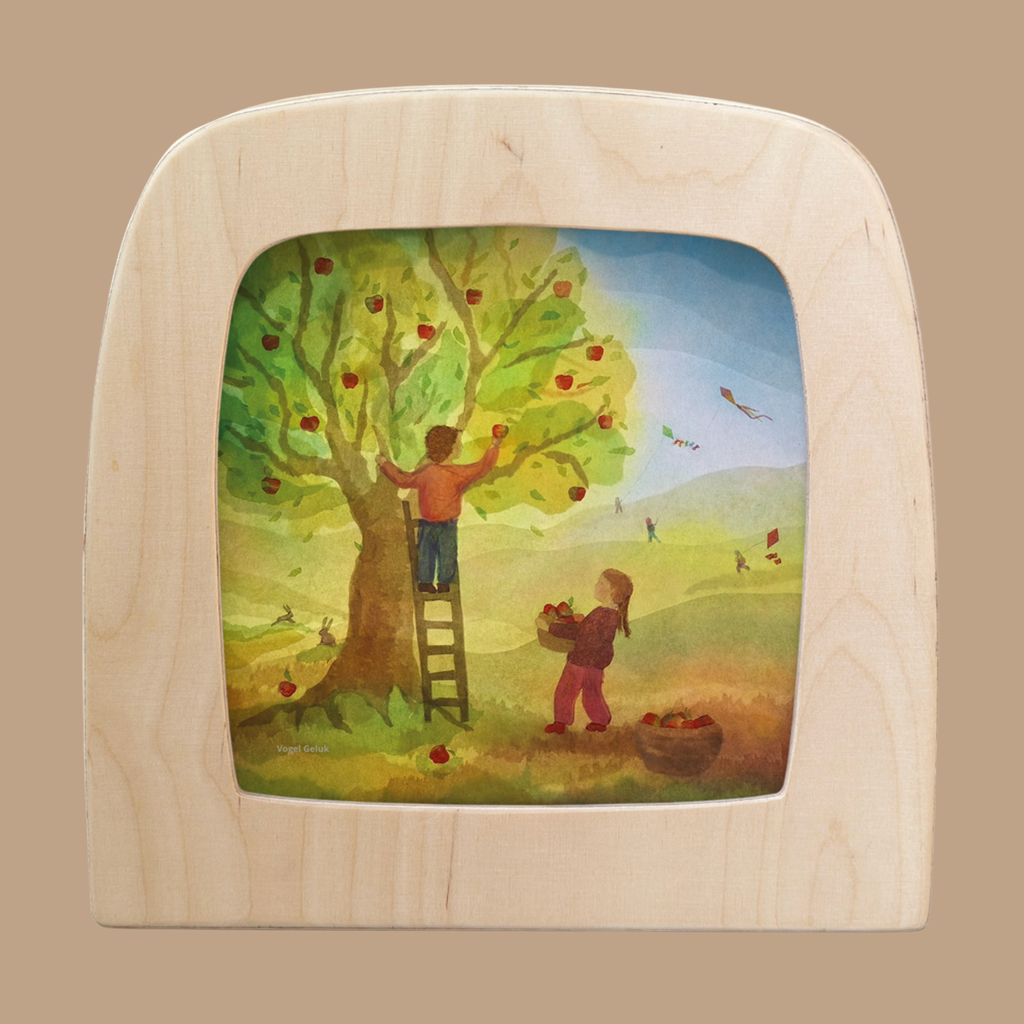 The Silhouette Only - Apple Tree for Toverlux Lamp shows a child on a ladder picking apples while another collects them in a basket, set in a vibrant outdoor scene with people and birds in the background.
