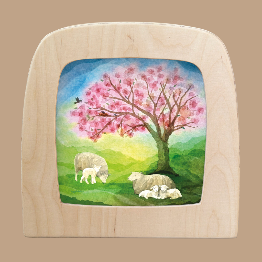 The "Silhouette Only - Little Lambs for Toverlux Lamp" features three sheep and a lamb under a pink-blossomed tree with birds in a hilly, colorful landscape—ideal for bringing charming decor to your home.