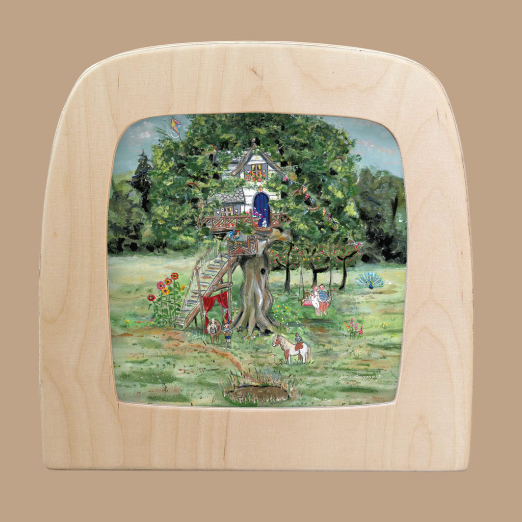 A whimsical treehouse silhouette with a blue door and leafy branches, featuring a child, animals, and flowers in the sunny garden. Translucent design fits the Silhouette Only - Treehouse for Toverlux Lamp; framed in light wood.