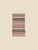 A folded Maileg Rug - Striped with a variety of colorful horizontal bands on a plain beige background.