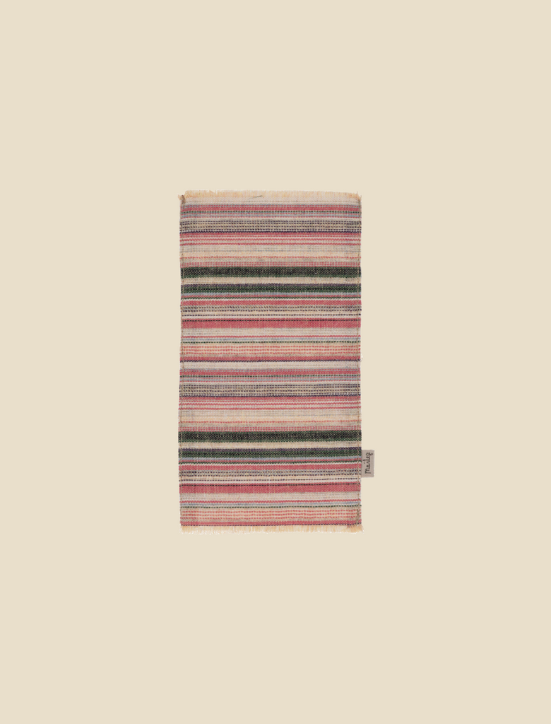 A folded Maileg Rug - Striped with a variety of colorful horizontal bands on a plain beige background.