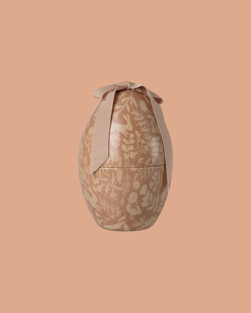 The Maileg Easter Egg, Medium - Powder features a floral pattern and a large ribbon, presented against a solid peach background.