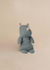 The Maileg Medium Rhino - Dusty Blue is a soft, blue-gray plush toy from our Safari Friends collection. Made from recycled polyester and soft fabric, it sits upright and features small patterned ears on a light beige background.