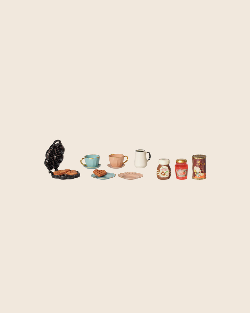 The PRE-ORDER: Maileg Waffle Set, Mouse (Estimated Arrival Mid October) features an open waffle maker with waffles, cups, saucers, a plate, pitcher, honey jar, jam, and cocoa can—all neatly arranged on a light background.