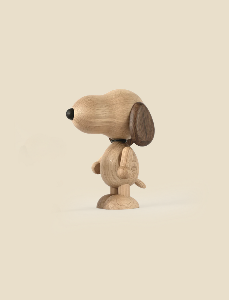 Boyhood Snoopy, Large cartoon-style beagle figurine with a prominent round head, small limbs, and a tail, made from different shades of wood, standing against a plain, light beige background.