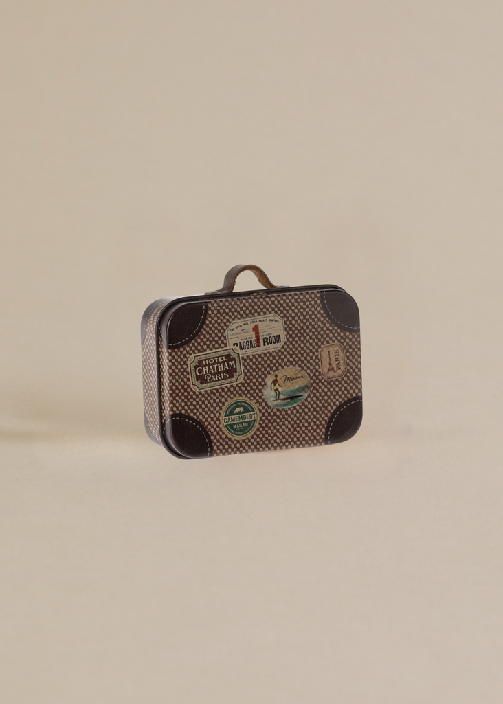 The Maile Bonus Room Bedroom Set includes a small vintage suitcase with a brown checkered pattern and travel stickers—ideal for accessorizing your Maileg dollhouse or adding charm to any miniature bedroom scene.