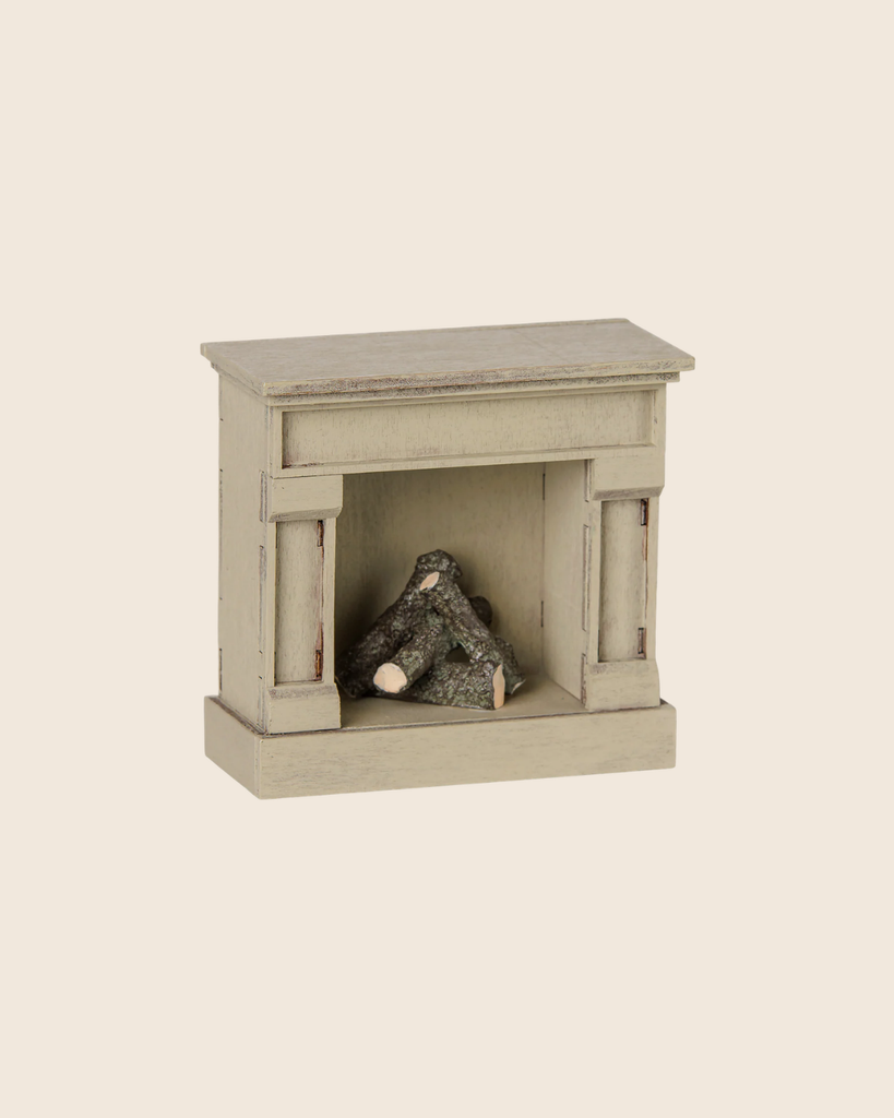 The PRE-ORDER Maileg Fireplace, Mouse in Off White (arriving mid August) features realistic wooden logs and a vintage finish, perfect for adding charm to any miniature home. Shown against a plain light background.