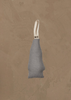The Coral & Tusk North Pole Bear Ornament hangs against a textured beige wall, its gray fabric and white loop handle adding a cozy, festive touch reminiscent of classic Christmas tree decorations.