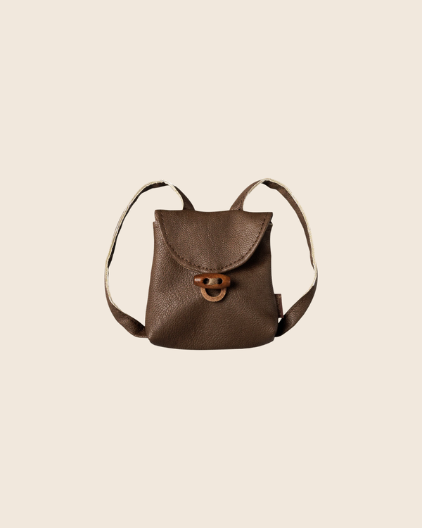 PRE-ORDER: Maileg Backpack, Medium Mouse—small brown leather backpack with front flap, wooden toggle closure, and two shoulder straps. Displayed on a beige background for a charming vintage look. Estimated arrival early November.