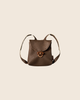 PRE-ORDER: Maileg Backpack, Medium Mouse—small brown leather backpack with front flap, wooden toggle closure, and two shoulder straps. Displayed on a beige background for a charming vintage look. Estimated arrival early November.