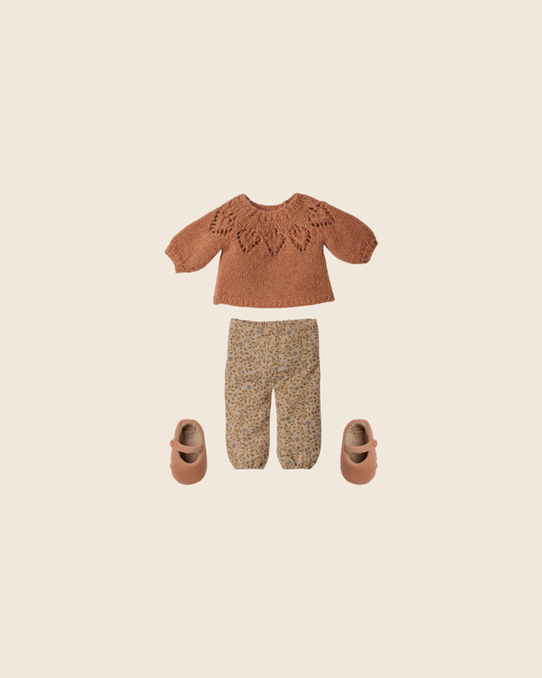 A flat lay of the PRE-ORDER: Maileg Pants and Knitted Sweater, Size 3 (Estimated Arrival Early November), with a decorative patterned brown sweater, flower-printed pants, and light brown shoes on a beige background.