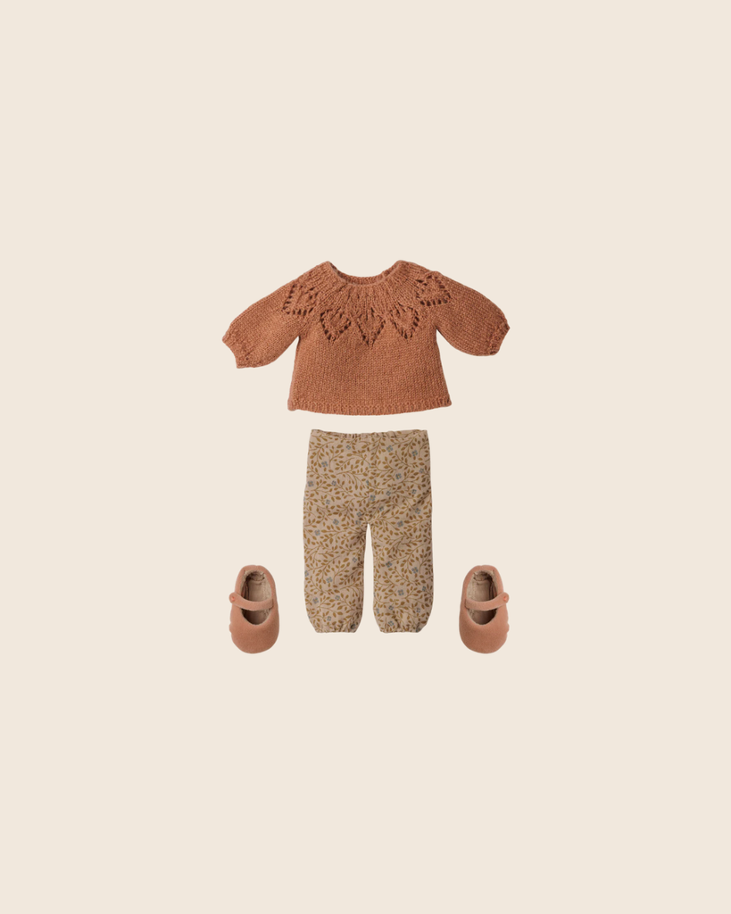 A flat lay of the PRE-ORDER: Maileg Pants and Knitted Sweater, Size 3 (Estimated Arrival Early November), with a decorative patterned brown sweater, flower-printed pants, and light brown shoes on a beige background.