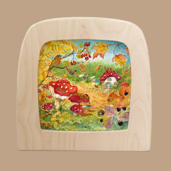 A Silhouette Only - Gnome Village Silhouette for Toverlux Lamp captures a whimsical forest scene featuring red mushrooms, a mushroom house, birds, flowers, berries, and autumn leaves along a grassy path under a blue sky—evoking the enchanting charm of a magical gnome village.