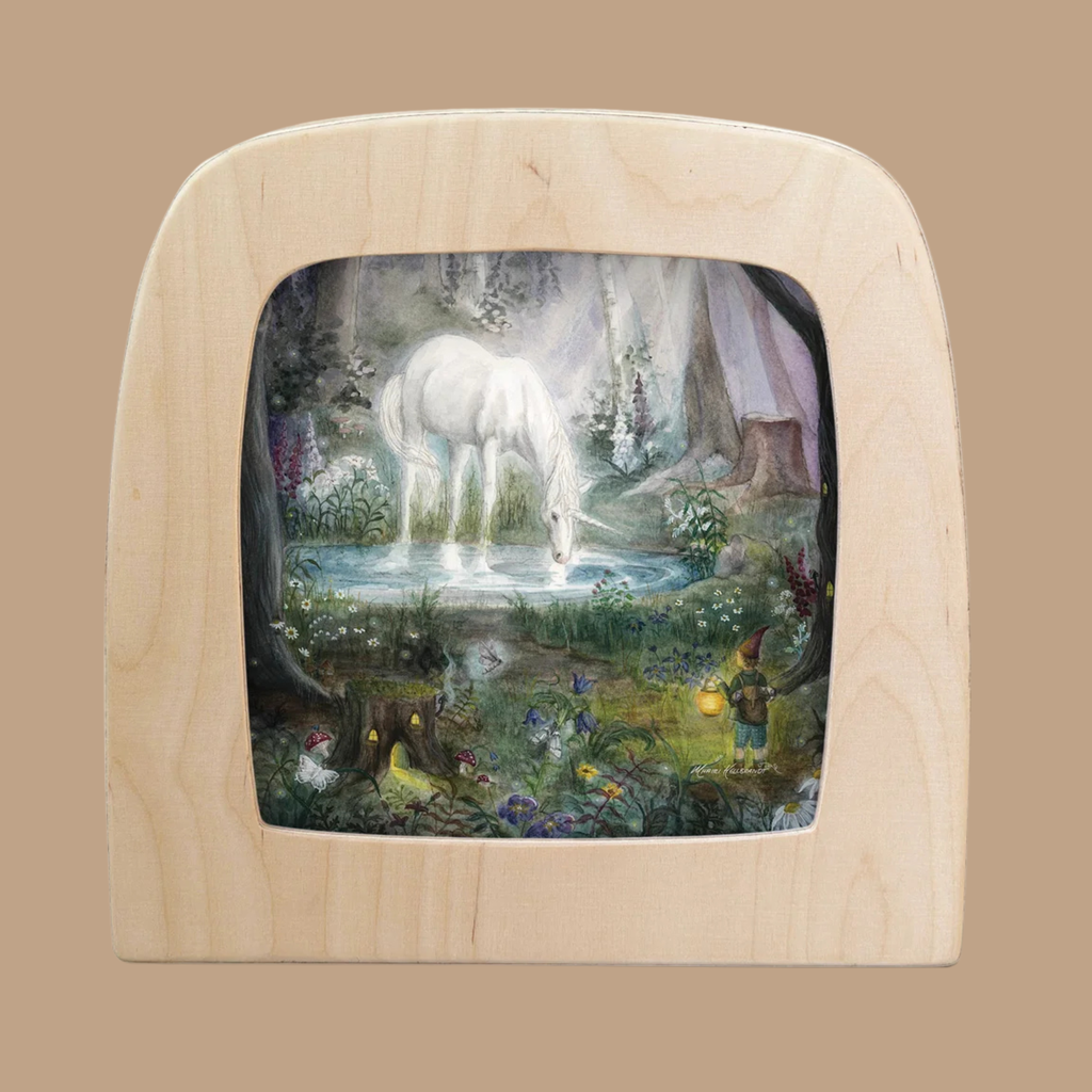 An enchanting silhouette features a unicorn sipping from a pond in an enchanted forest, with a gnome holding a lantern nearby and a deer amidst flowers—showcasing the magic of the Silhouette Only - Enchanted Forest Silhouette for Toverlux Lamp.