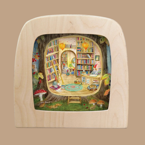 Transform your space with “The Secret Library Silhouette”—a cozy, whimsical library scene inside a tree featuring bookshelves, a ladder, two gnomes reading, colorful rugs, lanterns, and mushrooms—all framed by a light wood border. Designed exclusively for the Toverlux Lamp as part of the enchanting Toverlux Magic Silhouettes collection, this silhouette brings storybook wonder and truly unique home decor to any room.