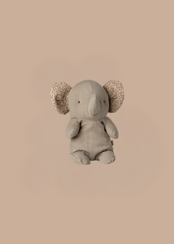 The Maileg Elephant, Small - Iron Grey, a soft stuffed toy with patterned inner ears, sits upright against a plain beige background.