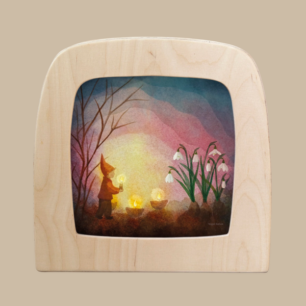 The "Silhouette Only - Kindling Spring for Toverlux Lamp" features a gnome holding a lantern among glowing lights, with bare branches and snowdrops against a colorful sky—an enchanting decor accent.