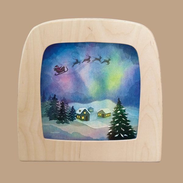 Bring a festive glow to your space with the “Silhouette Only - Aurora Sleighride Silhouette for Toverlux Lamp.” This enchanting translucent artwork features Santa’s sleigh and reindeer soaring above snowy homes and pine trees beneath a vibrant aurora borealis night sky. Reminiscent of Magic Silhouettes, this decorative piece casts a magical, heartwarming light when displayed with your Toverlux Lamp.
