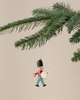 A Christmas tree branch displays the Maileg Metal Ornament, Guard - Drum: a hand-painted toy soldier with a black hat, red shirt, and blue pants—part of the charming Maileg ornaments collection.