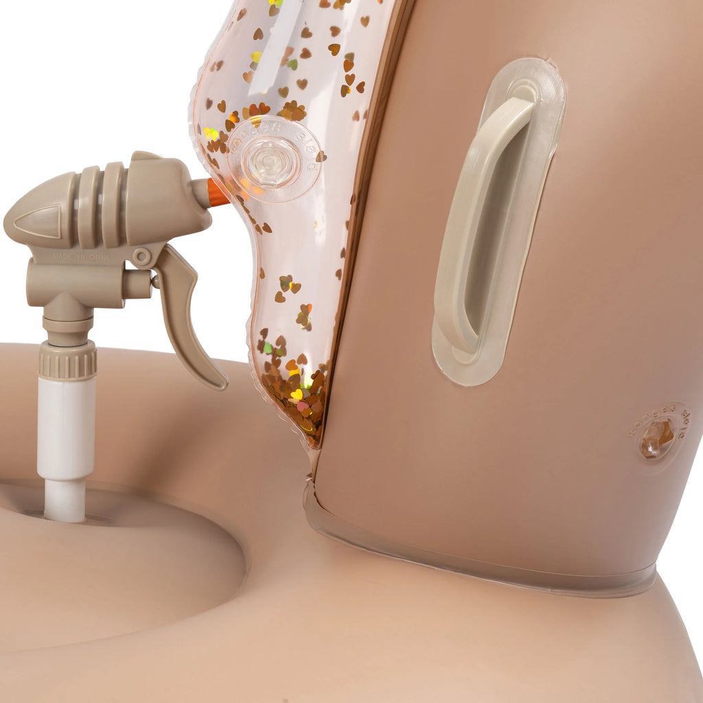 Close-up of a beige Inflatable Water Splasher Float - Unicorn with a transparent PVC dust container filled with dust and debris, highlighting the suction hose attached to it.