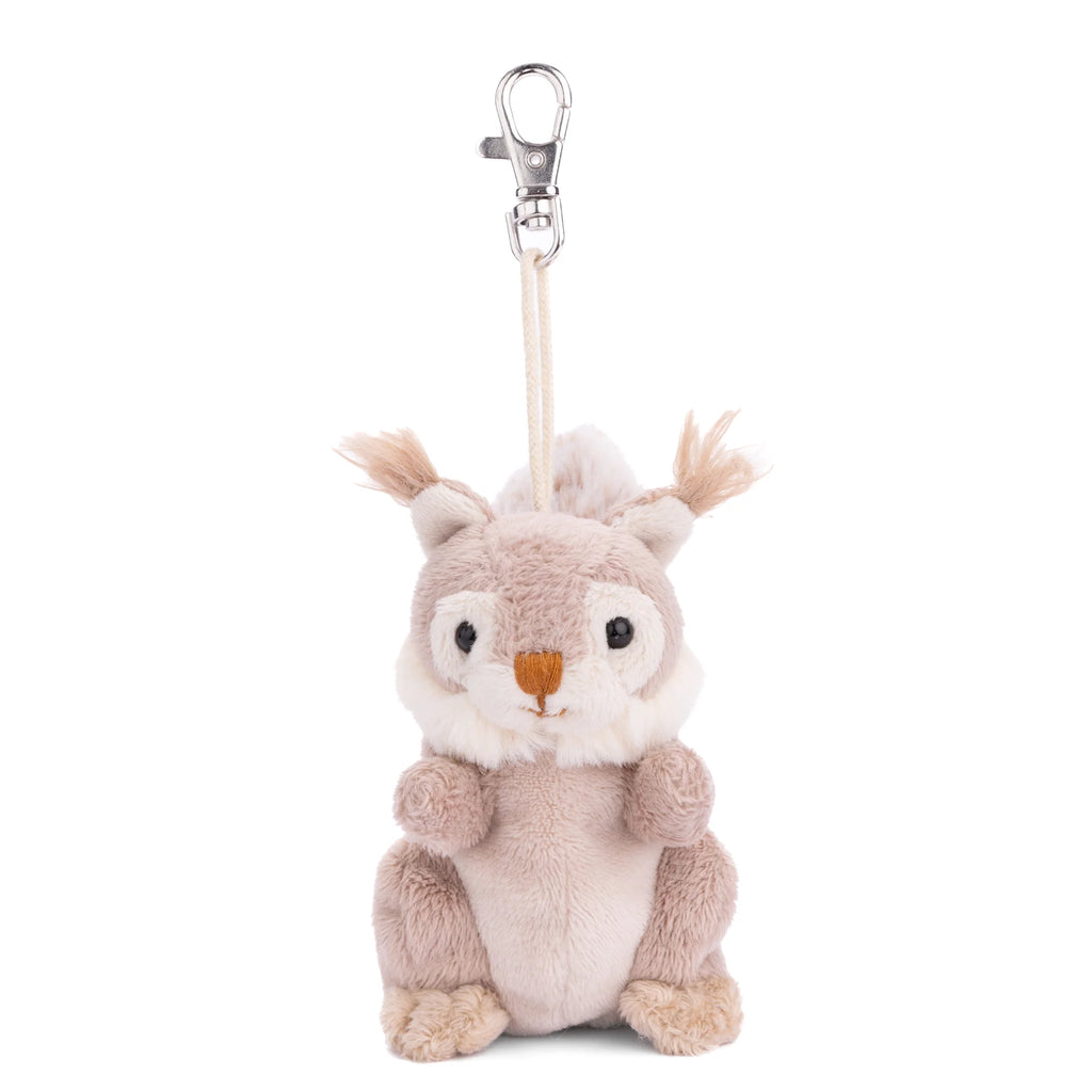 The Bukowski - Wiggles Squirrel Bag Charm features a plush squirrel with light brown fur, a white belly, and a small orange nose, sitting upright with a metal clasp attached to a short string on its head—making this adorable accessory the perfect woodland-themed keychain for any nature lover.
