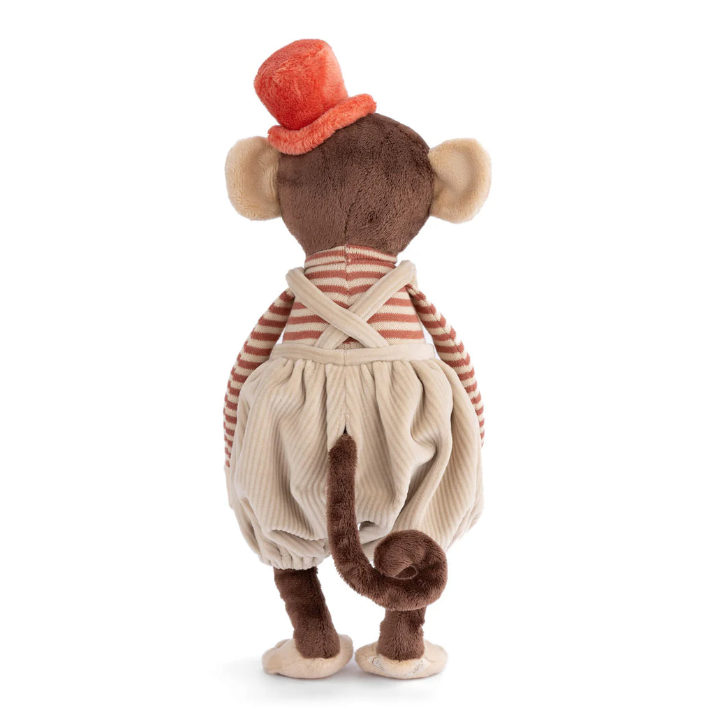 The Bukowski - Winston Monkey - Tan plush toy faces away, showing its brown curly tail and wearing an orange top hat, striped shirt, cream suspenders, and baggy cream pants.