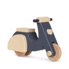 A small, wooden *Wooden Scooter* crafted from responsibly sourced beech wood and painted in navy blue and beige with nontoxic paint. The minimalist design features round wooden wheels and a simple handlebar. The seat and the rear section are beige, contrasting beautifully with the navy blue body.