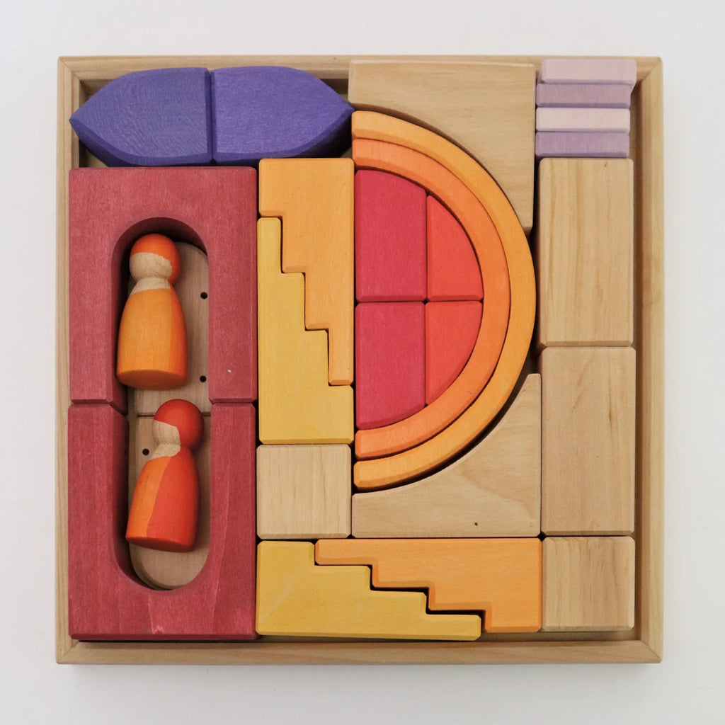 A wooden frame filled with a variety of colorful geometric Grimm’s Building World - Desert Sand blocks and two small wooden peg people for imaginative free building.