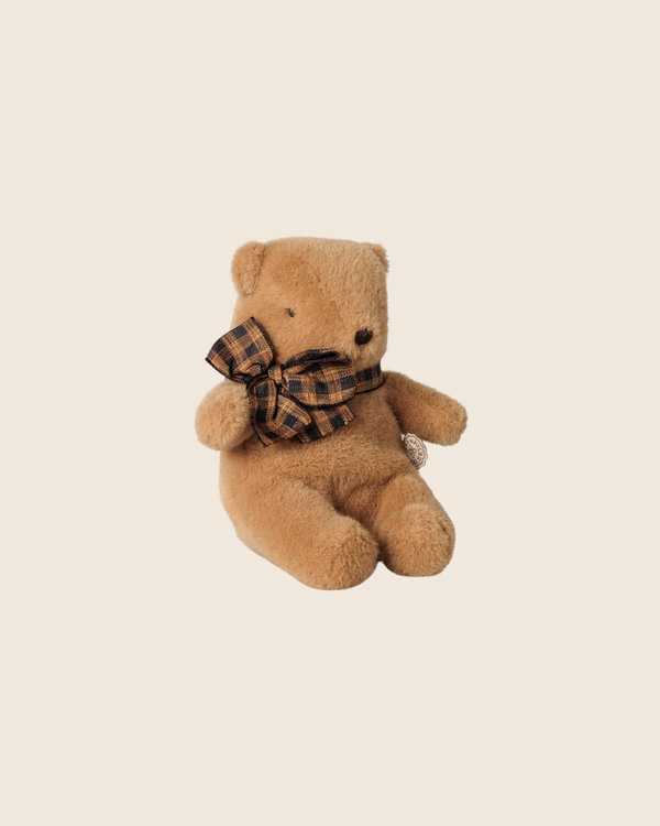 The PRE-ORDER: Maileg Teddy Bear Plush, Mini - Mushroom, featuring a large plaid bow, sits upright against a plain beige background. Estimated arrival early October.