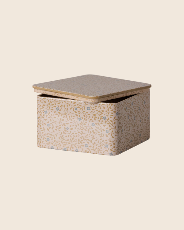 The PRE-ORDER: Maileg Metal Box - Branches features a square, light-colored metal design with a delicate gold and light blue floral pattern on the lid, partially open, set against a plain beige background.