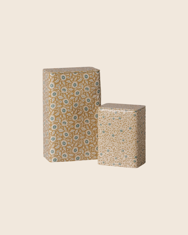 The PRE-ORDER: Maileg Metal Box Set - Flowers - Ocher/Blue (Estimated Arrival Early October) features two rectangular metal boxes with vintage floral prints in beige, blue, and white—one tall and one short—set against a light beige background.