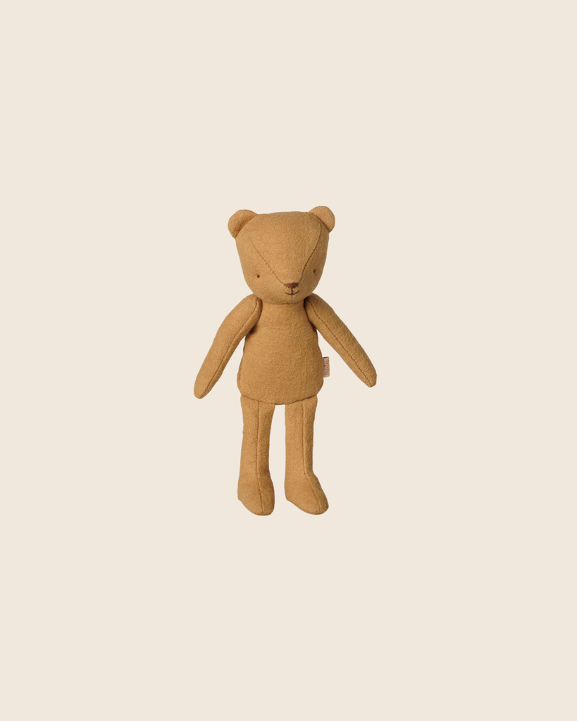 The PRE-ORDER: Maileg Teddy Junior - Cream Yellow features soft cotton and stitched details, standing upright against a light beige background for a charming vintage appeal. Estimated arrival mid November.