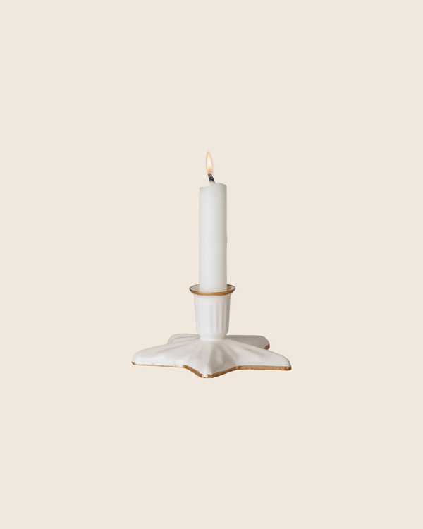 The PRE-ORDER: Maileg Christmas Candle Holder, Star, Small—a white ceramic piece with handpainted golden details—holds a lit white candle and is set against a plain light beige background.