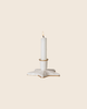 The PRE-ORDER: Maileg Christmas Candle Holder, Star, Small—a white ceramic piece with handpainted golden details—holds a lit white candle and is set against a plain light beige background.