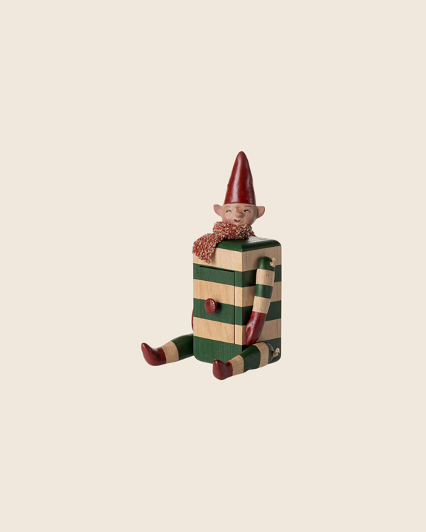 The PRE-ORDER: Maileg Elf with Drawer - Green is a festive collectible resembling an elf, designed as a gift box with red and green stripes, smiling face, red hat, scarf, and matching legs. Estimated arrival mid August.