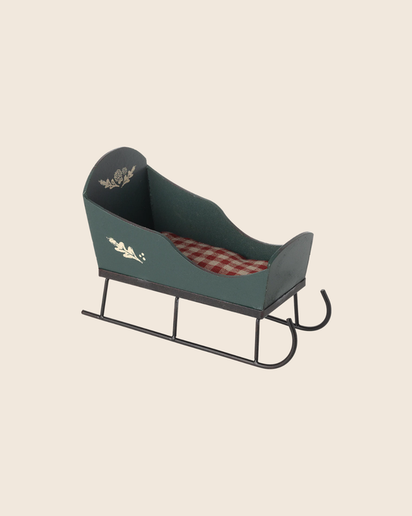 PRE-ORDER: Maileg Sleigh, Mini - Green features vintage-style gold handpainted details and a red-and-white checkered cushion. Perfect for mini pixies in holiday displays. Estimated arrival early September.