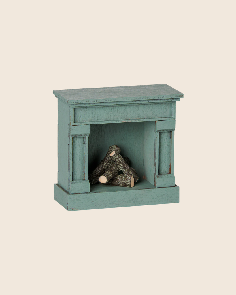 PRE-ORDER the Maileg Fireplace, Mouse - Blue: a small, vintage-finished wooden fireplace with stacked miniature logs, ideal for charming your miniature home. Estimated arrival mid August. Set against a light beige background.