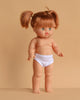 The Minikane Standing Doll (14") - Gabriella features light skin, green eyes, and brown pigtails. This anatomically correct, made-in-Spain doll comes wearing white underwear; clothing is sold separately. Stands against a beige background.