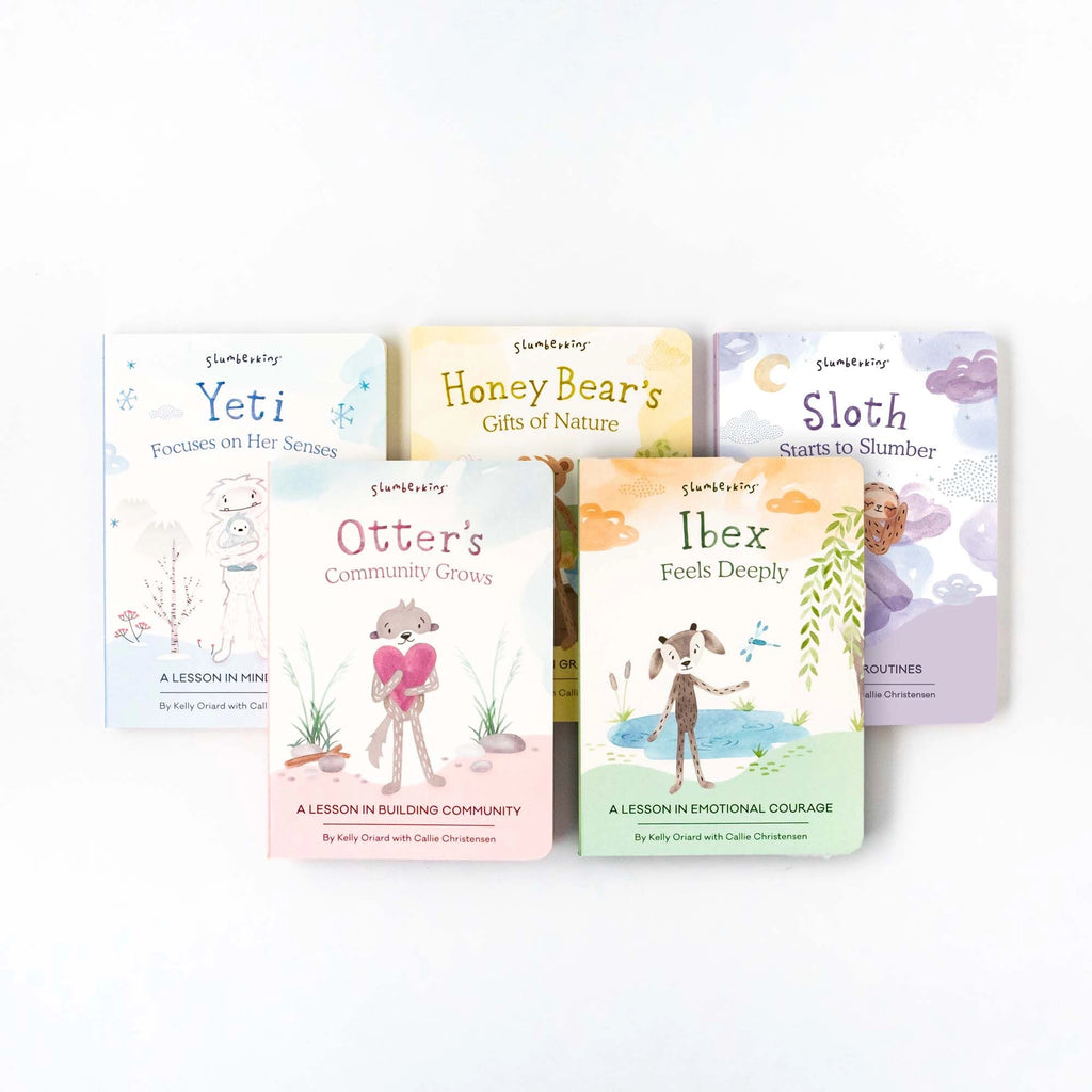 Four children's books from the "Slumberkins A Lesson in Caring Board Book Set" series laid flat, featuring cute illustrated animals like a yeti, honey bear, otter, and sloth.