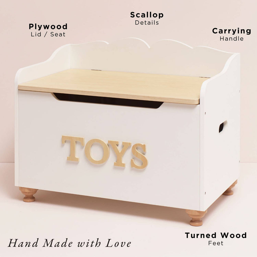 The Toy Storage Box is a white wooden chest with "TOYS" in bold letters, a light plywood lid, scalloped back detail, side carrying handles, and turned wood feet—a stylish and practical storage solution for kids’ toys.