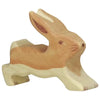 A small, handcrafted wooden rabbit figurine in a leaping pose. Made from maple and beech wood, the rabbit is painted in light brown and beige tones, with simple facial features and extended ears. This charming piece is reminiscent of Holztiger Rabbit, Running.