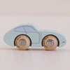 A charming vintage-inspired light blue wooden toy car, the No. 2 GT15 Jude by LE TOY VAN, features two natural wood wheels labeled “LE TOY VAN” and rests on a smooth, pale surface against a neutral background. Made in England, this delightful classic makes an ideal gift for children, blending timeless play value with elegant design.