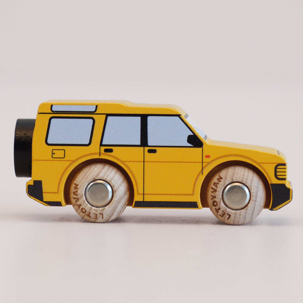 A No. 35 GT195 Riley, a yellow wooden 4x4 toy SUV with black windows and details, made in England, perfect for imaginative play, photographed from the side on a neutral background.