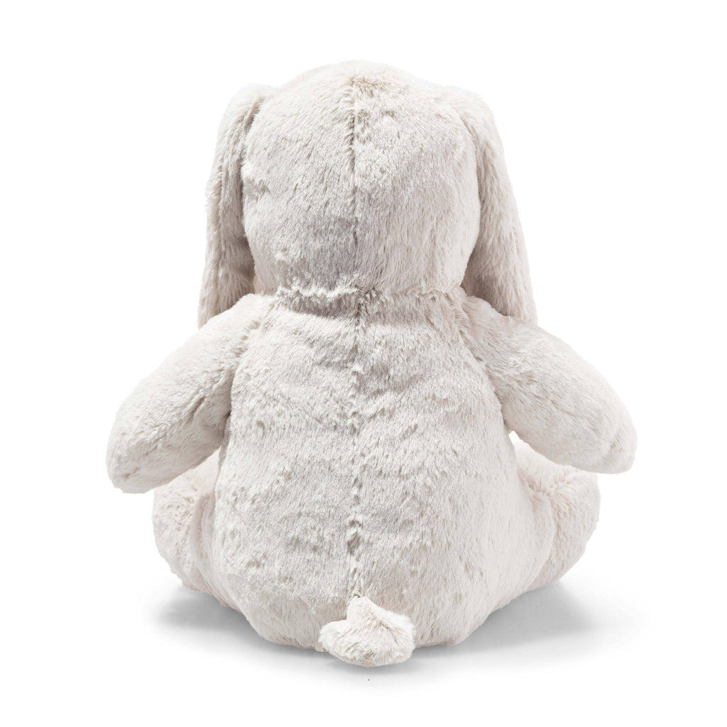 The Steiff Hoppie Bunny Stuffed Animal is a fluffy, light-colored plush, shown from the back sitting upright, with long drooping ears and a small round tail at the bottom.
