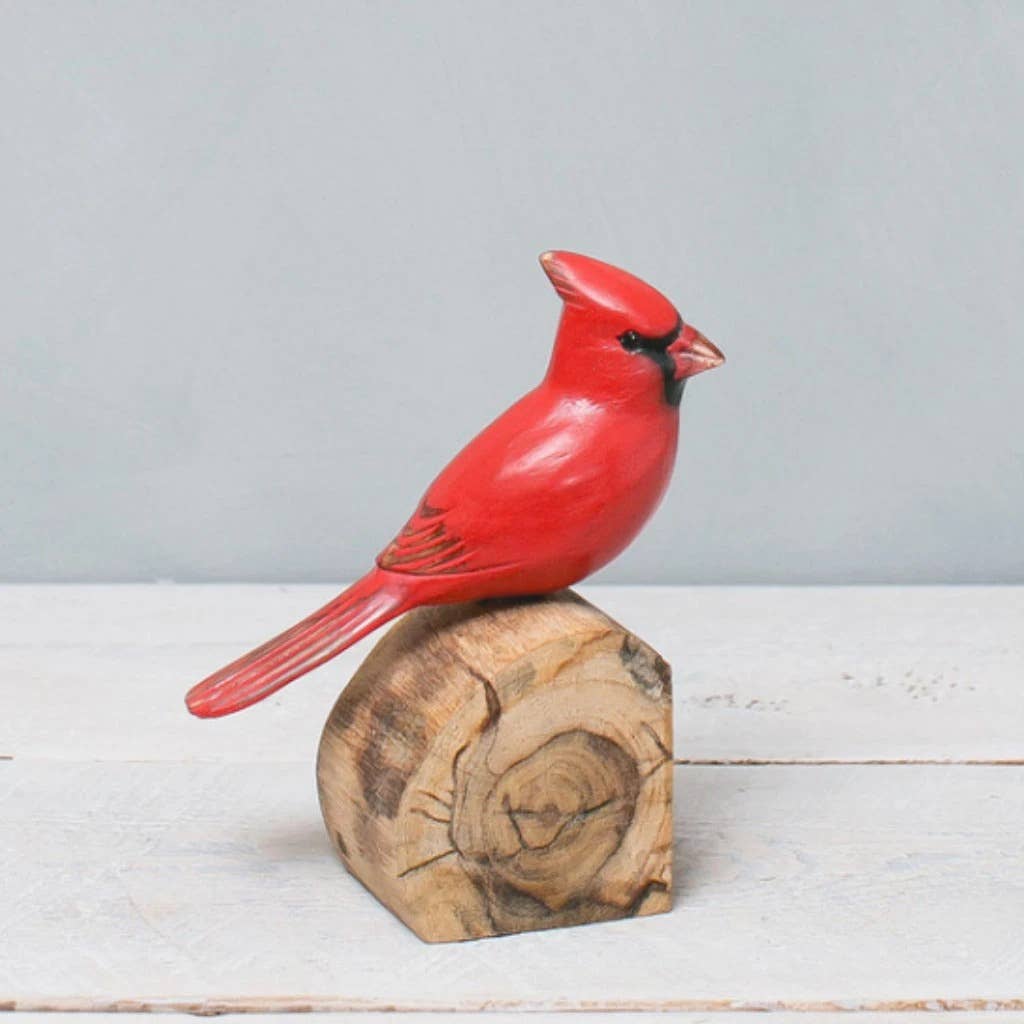 The Hand Carved Ornament - Cardinal Bird - Male - 7"H features a vivid red cardinal with a black face mask perched on natural wood, making it a charming anniversary gift against a light gray background.