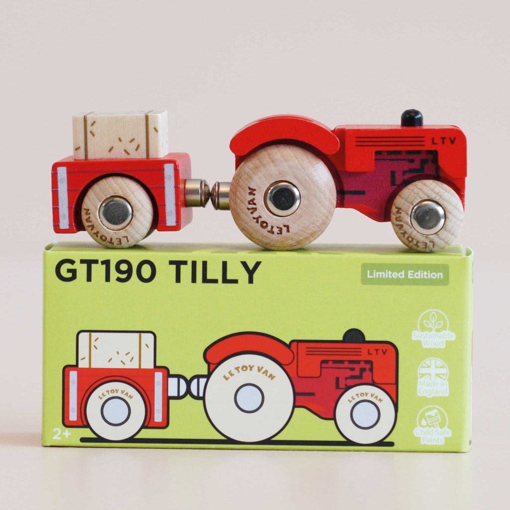A charming red vintage wooden tractor with a trailer sits atop a green box labeled “No. 34 GT190 Tilly | Made in England.” Perfect as a farmyard toy, the box features an illustration of the tractor and trailer, showcases “Limited Edition” alongside safety icons, and invites hours of imaginative play.