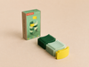 A box labeled “WaytoPlay: Arches - Starter Set” stands next to a stack of plastic curved arches in yellow, dark green, and light green, all arranged neatly on a beige surface—perfect for imaginative play with this creative building set.