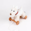 Pull-Along Lola is a plush white dog pull-along toy with a red plaid collar, wooden wheels, and a pull string—ideal for encouraging gross motor skills.